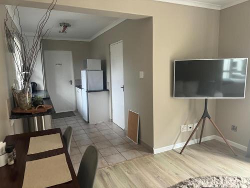 ein Wohnzimmer mit einem Flachbildfernseher an der Wand in der Unterkunft The Cottage on Alphen in Heathfield