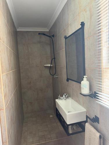 a bathroom with a sink and a mirror at The Cottage on Alphen in Heathfield