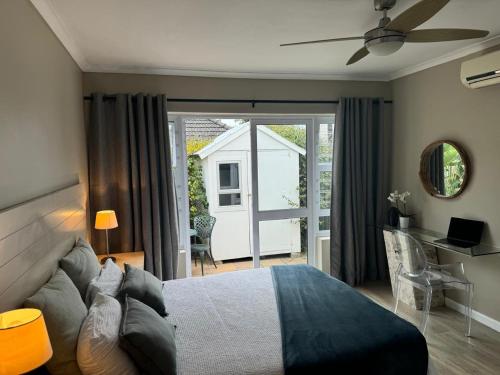 a bedroom with a bed and a sliding glass door at The Cottage on Alphen in Heathfield