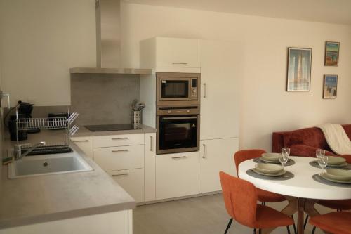 une cuisine avec une table et un comptoir dans l'établissement Maison Nature & Océan, à Grayan-et-lʼHôpital