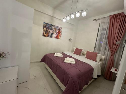 a bedroom with a bed with a purple blanket at Estia House M in Nikiti