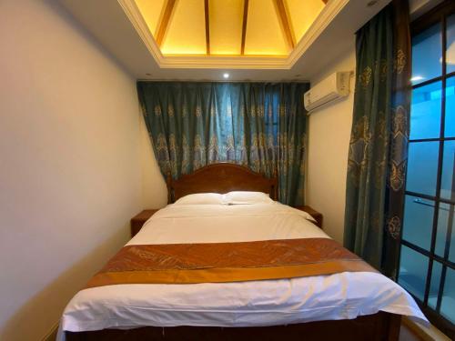 a small bedroom with a bed with a window at Perfume Bay Tianhai Meiya B&B in Lingshui
