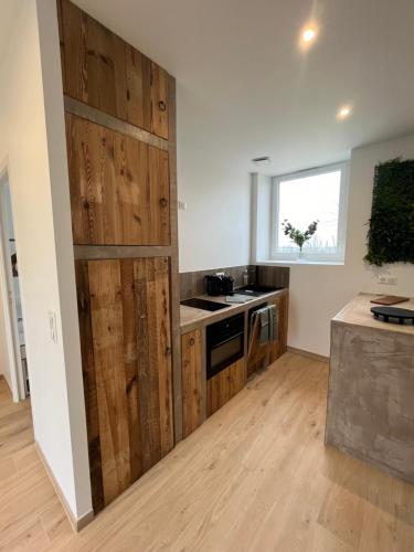 une cuisine avec une porte en bois au milieu dans l'établissement Gîte du Grand Caugy, à Saint-Vigor-le-Grand