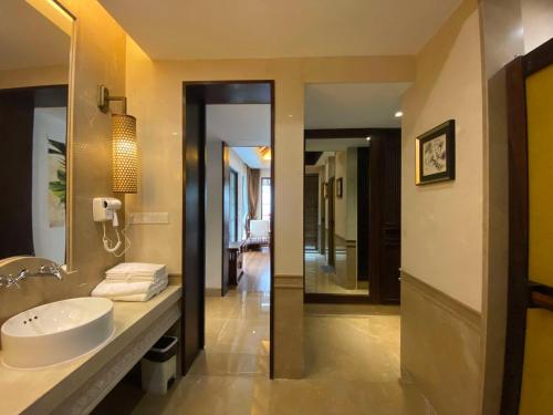 a bathroom with a sink and a mirror at Perfume Bay Tianhai Meiya B&B in Lingshui