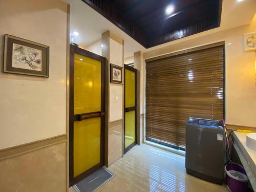 a hallway with a yellow door and a window at Perfume Bay Tianhai Meiya B&B in Lingshui