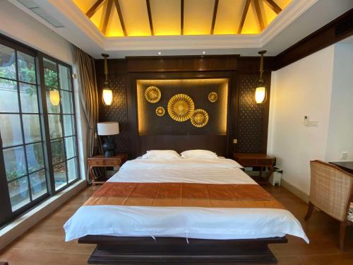 a bedroom with a large bed in a room with windows at Perfume Bay Tianhai Meiya B&B in Lingshui