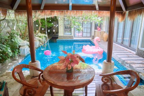 a pool with a table and a pink swan in a pool at Perfume Bay Tianhai Meiya B&B in Lingshui