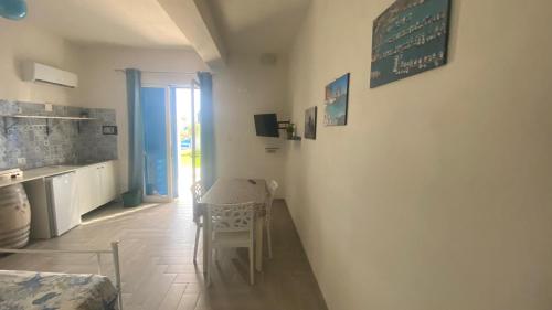 a kitchen with a table and a chair in a room at Casa Vacanze-Le stanze di Eolo in Marsala