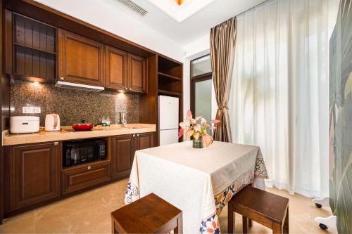 a kitchen with a table and some chairs and a counter at Perfume Bay Tianhai Meiya B&B in Lingshui