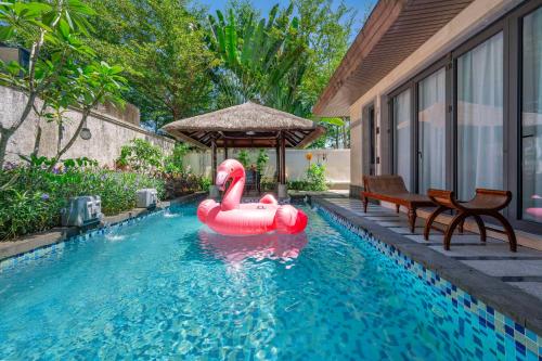 a pool with a pink inflatable flamingo in the water at Perfume Bay Tianhai Meiya B&B in Lingshui