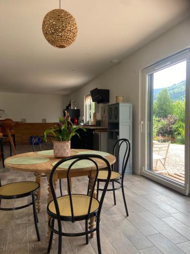 une cuisine et une salle à manger avec une table et des chaises dans l'établissement Coquette maison neuve de plain pied au cœur des Hautes Vosges,, à Thiéfosse