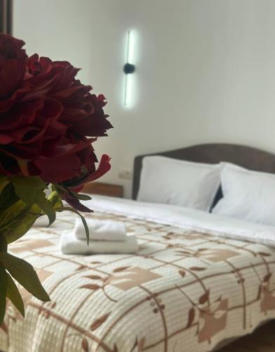 a bedroom with a bed with a flower on it at La Dolce Casa in Almaty