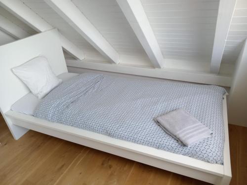 a white bed in a attic with a pillow at VK - H - Zürich Airport - Luxury - Homestay - Haldenstrasse - Kloten in Kloten