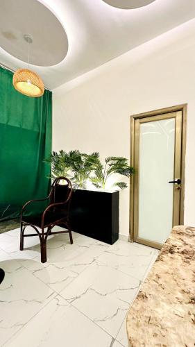 a room with a chair and a door with plants at New Green Horse Hotel in Cotonou