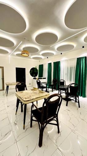 a room with tables and chairs and green curtains at New Green Horse Hotel in Cotonou