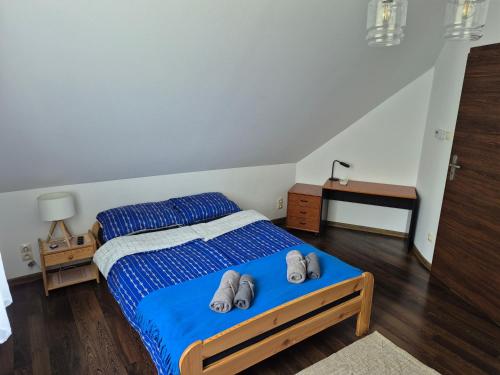 a bedroom with a bed with two slippers on it at Domek na Mazurach-Piasutno in Piasutno