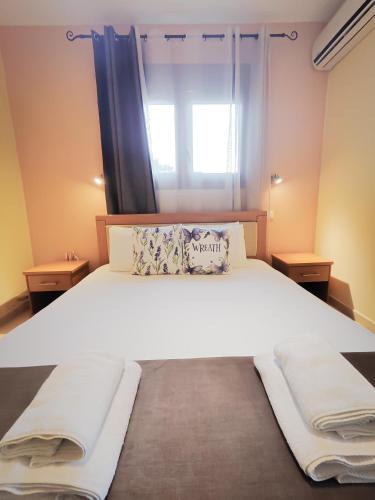 a bedroom with a large white bed with a window at Lavender Apartments in Skala Potamias