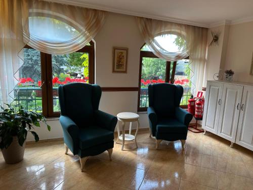 two chairs and a table in a room with windows at Oleander House and Tennis Club in Sunny Beach