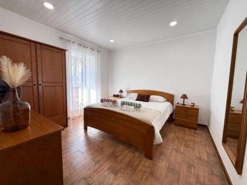a bedroom with a bed and a vase on the floor at Baleeiro do Cais:Harbour House, Fishing, Fireplace in Ponta Delgada