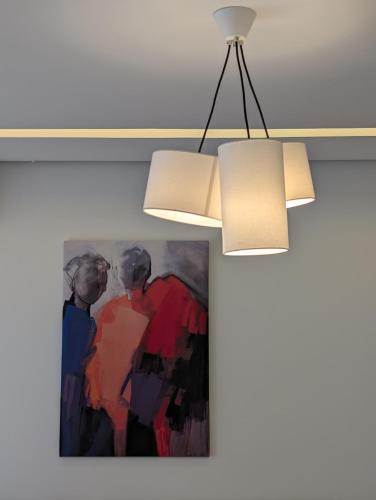a painting hanging on a wall next to a light fixture at Dar Fatma Luxury apartment with sea view in Hammamet Sud