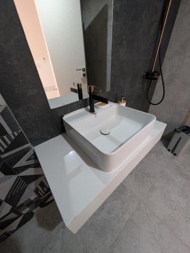 a bathroom with a white sink and a mirror at Dar Fatma Luxury apartment with sea view in Hammamet Sud