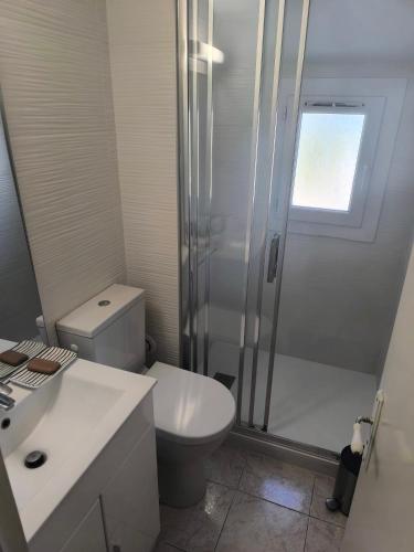 une salle de bain blanche avec toilettes et douche dans l'établissement Duplex 6pers mer et piscine, à Roquebrune-sur Argens