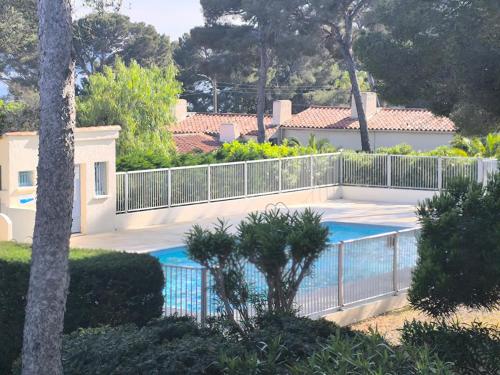 une piscine avec une clôture à côté d'une maison dans l'établissement Duplex 6pers mer et piscine, à Roquebrune-sur Argens