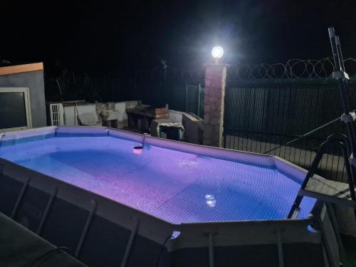 a swimming pool lit up at night with a light at Casa Nadiia in Cinisi