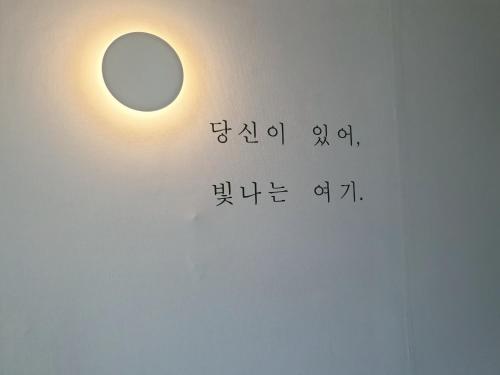 a light on a wall with a mathematics equation at LibeStay in Busan