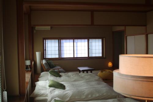 a room with a bed with pillows on it at Tranquil Mountain Getaway - Breathtaking Scenery right next to Nakasendo Trail in Nagiso
