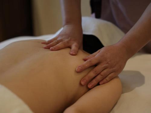 a woman is getting her belly pierced with her hands at Yangshuo Lisa Boutique Hotel in Yangshuo