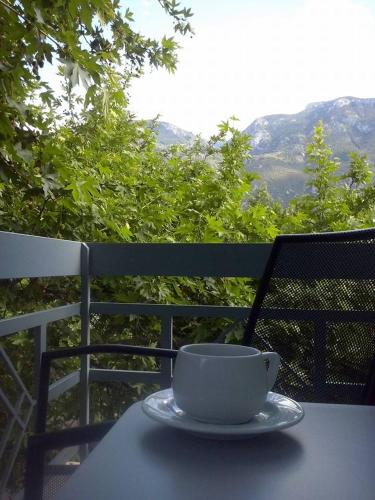 a coffee cup sitting on a table on a balcony at Ermis in Loutra Ipatis