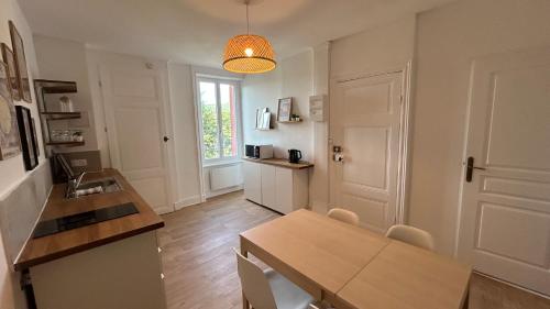 une cuisine avec une table et une salle à manger dans l'établissement Appartement du Petit Bourg, à Thizy-les-Bourgs