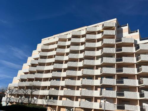 Il propose un grand appartement doté d'un balcon blanc. dans l'établissement À Deux Pas de la Mer charmant T2, à Canet