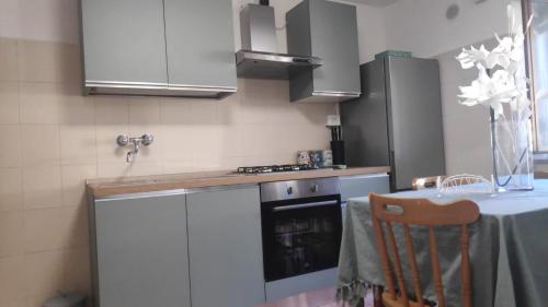 a kitchen with white cabinets and a stove and a table at Belvedere Escher in Pettorano sul Gizio