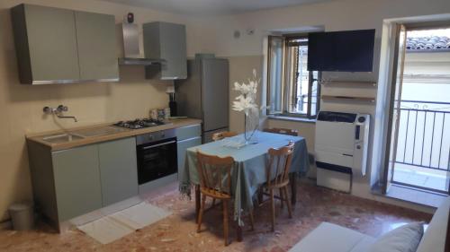a kitchen with a table with a vase of flowers on it at Belvedere Escher in Pettorano sul Gizio