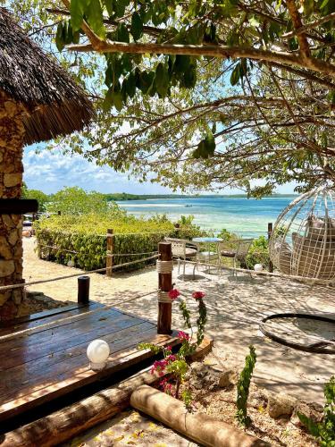 a wooden bench with a view of the ocean at Rock and Sea Resort in Watamu