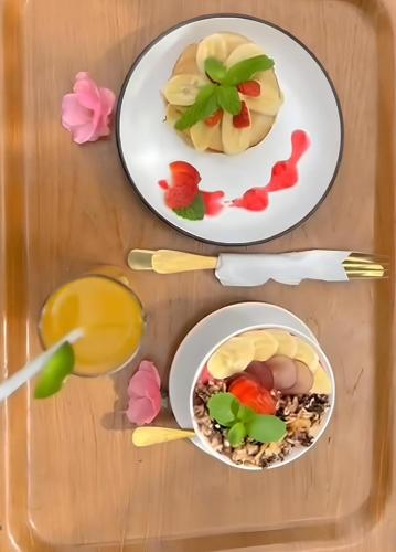 two plates of food on a wooden table with food at Angel Bali Suites in Selat