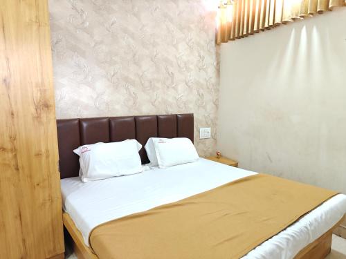 a bed with two white pillows on top of it at Prime Residency in Kolhapur