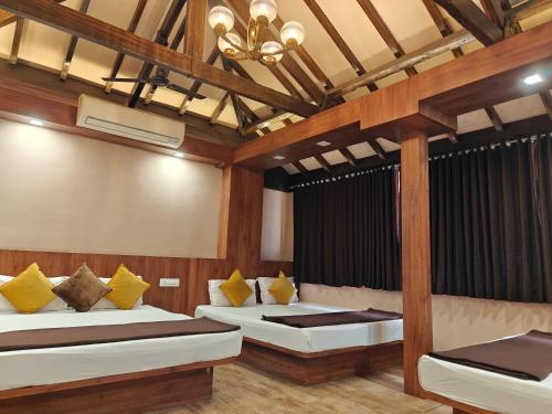 a room with two beds and a chandelier at Prime Residency in Kolhapur