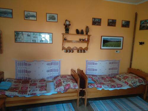 a bedroom with two beds and pictures on the wall at Apartmán U Bartoloměje in Verneřice
