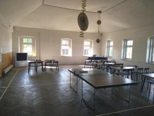 an empty room with tables and chairs and windows at Apartmán U Bartoloměje in Verneřice