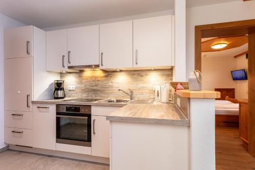 a kitchen with white cabinets and a sink at Hagerhof in Walchsee