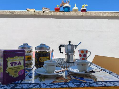 a table with two cups of coffee and a tea pot at Versante est in Casamassella