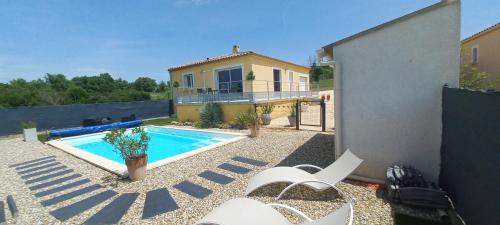 une cour arrière avec une piscine et une maison dans l'établissement Charmante maison lumineuse avec piscine, jolie vue, à Potelières