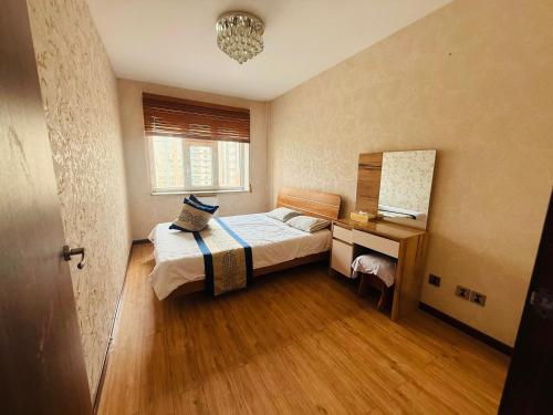 Un dormitorio con una cama y un escritorio con espejo. en Crown apartment 3 room, en Ulán Bator