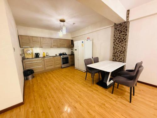 Una cocina y un comedor con mesa y sillas. en Crown apartment 3 room, en Ulán Bator