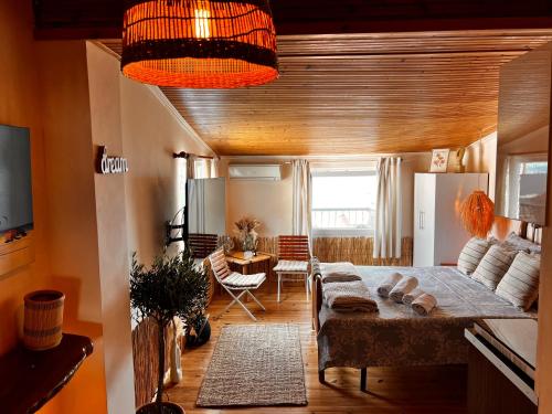 a living room with a bed and a table at Agape Studios in Neos Marmaras