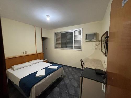 a small bedroom with a bed and a window at Xantara Hotel in Goiânia