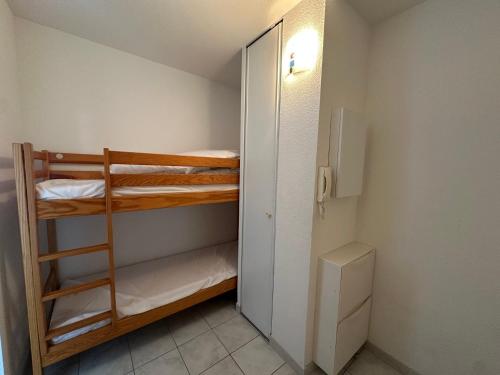Cette petite chambre comprend 2 lits superposés et un placard. dans l'établissement T2 cabine avec climatisation et parking, 5 personnes à Sète - FR-1-472-208, à Sète